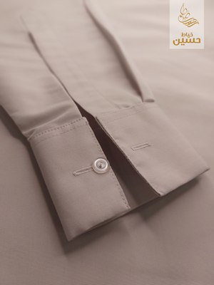Close-up of the sleeve placket button and dangling thread detail